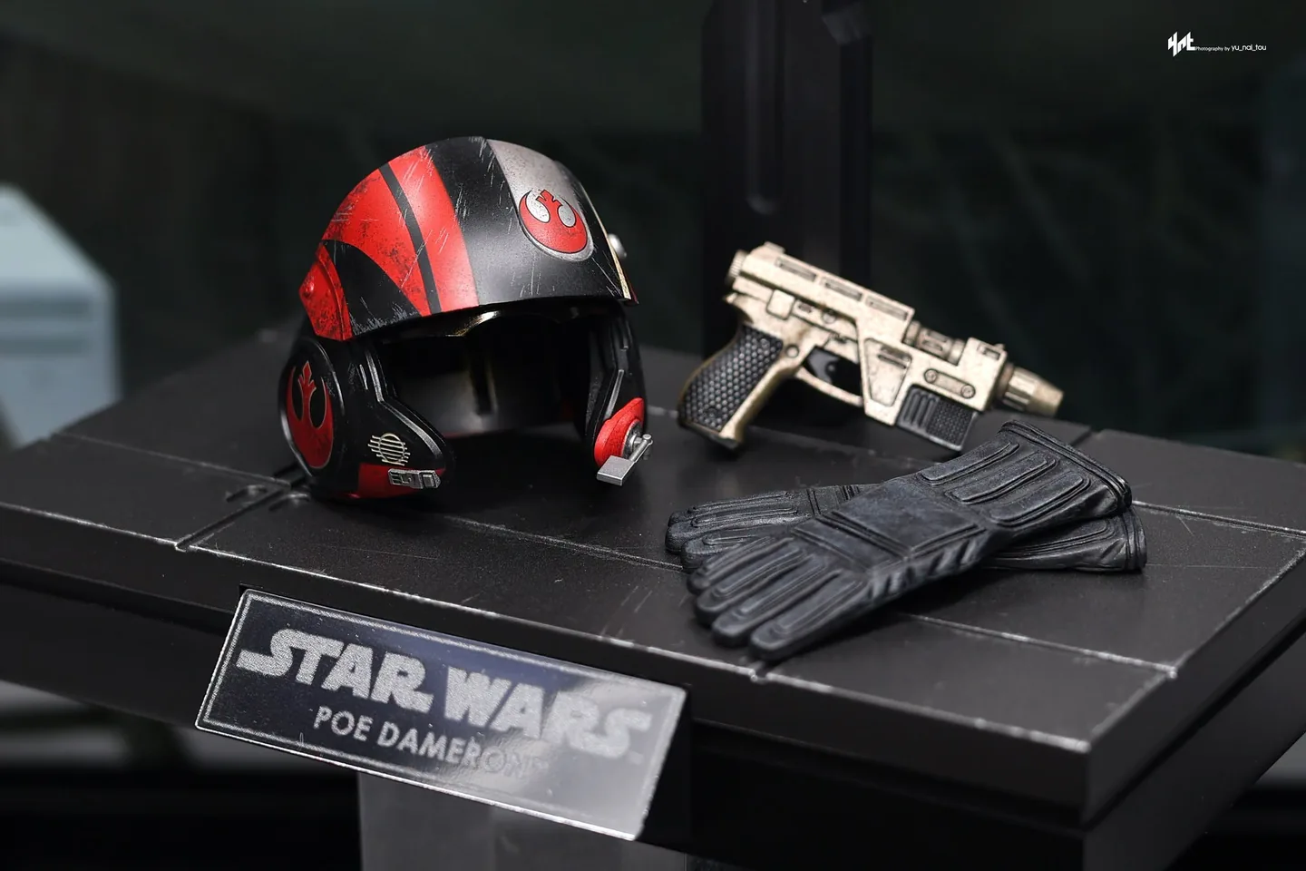 Final production review photo of Hot Toys Poe Dameron showing the included helmet, blaster, gloves and display stand.