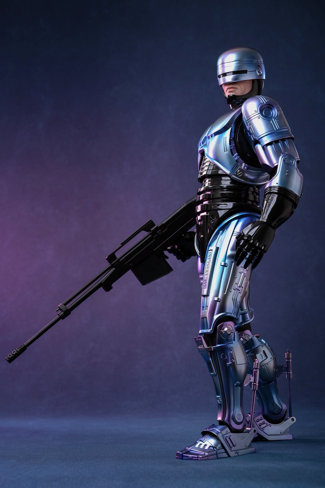 Full-body Hot Toys RoboCop 2 display pose with the Cobra Assault Cannon, showing the legs, ankles and mechanical pistons.