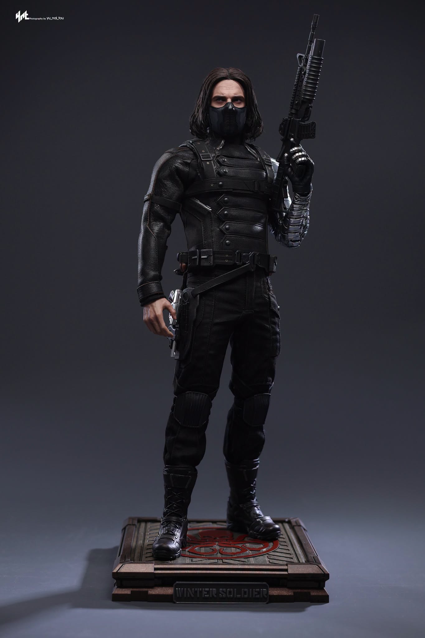 Final production review photo of Hot Toys Winter Soldier Artisan standing on the Hydra display base with a rifle.